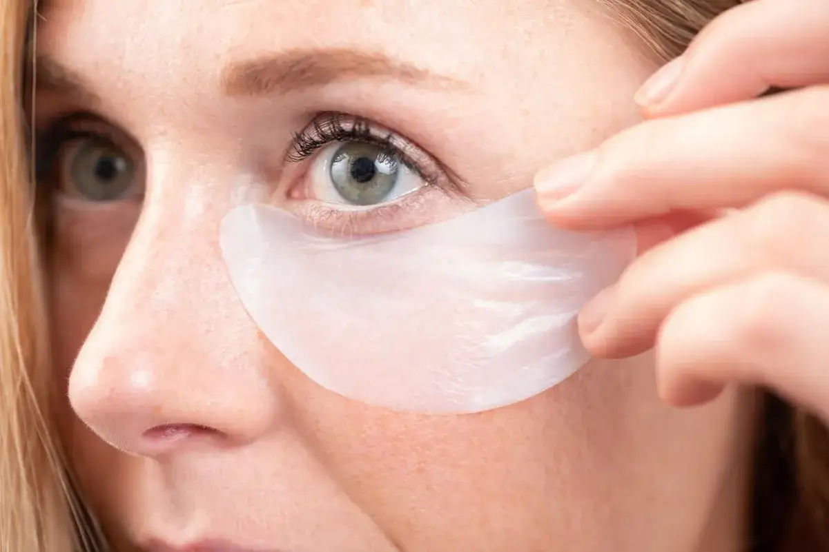 Ojos con mirada cansada, a los que se les aplican parches para el contorno de ojos.