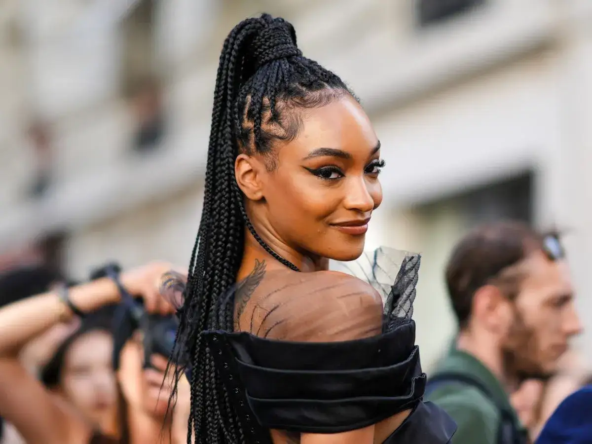 Mujer con peinado de trenzas altas y maquillaje dramático. ¡Inspiración para tus próximas ideas de trenzas!