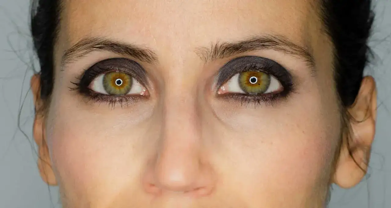 Ojos verdes con un sutil maquillaje ahumado natural, resaltando la mirada con tonos oscuros y difuminados.