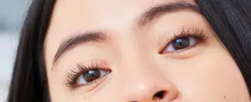 Ojos marcados con pestañas largas y cejas definidas.