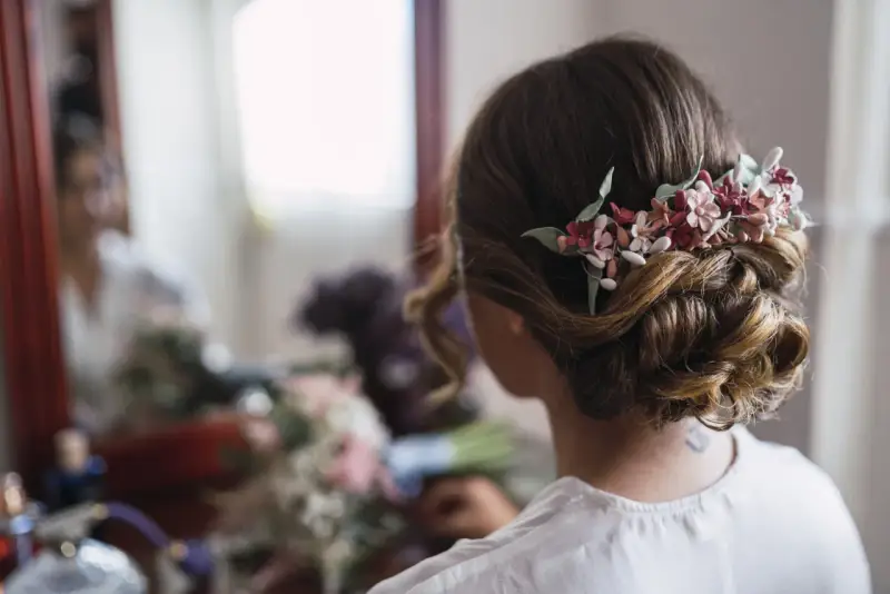 Un elegante moño bajo adornado con flores delicadas, perfecto para un día especial.