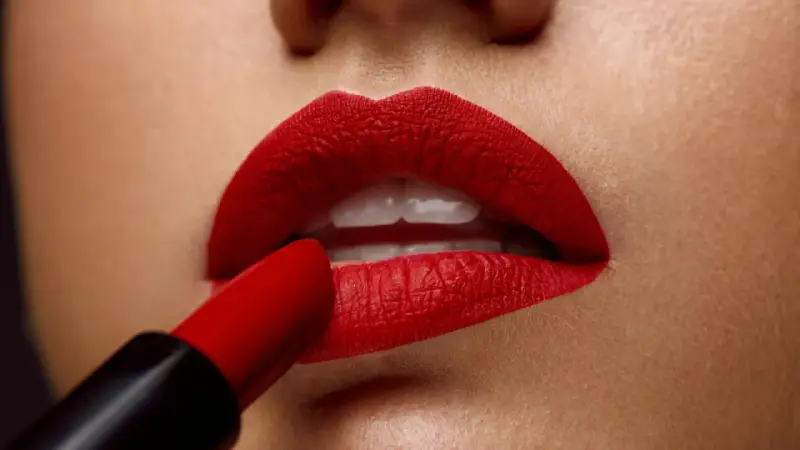 Labios perfectamente definidos con un intenso maquillaje de labios rojos, aplicados con un labial carmesí.